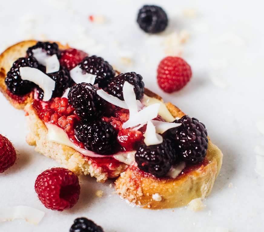 Toast with caramelized raspberries, blackberries and coconut chips